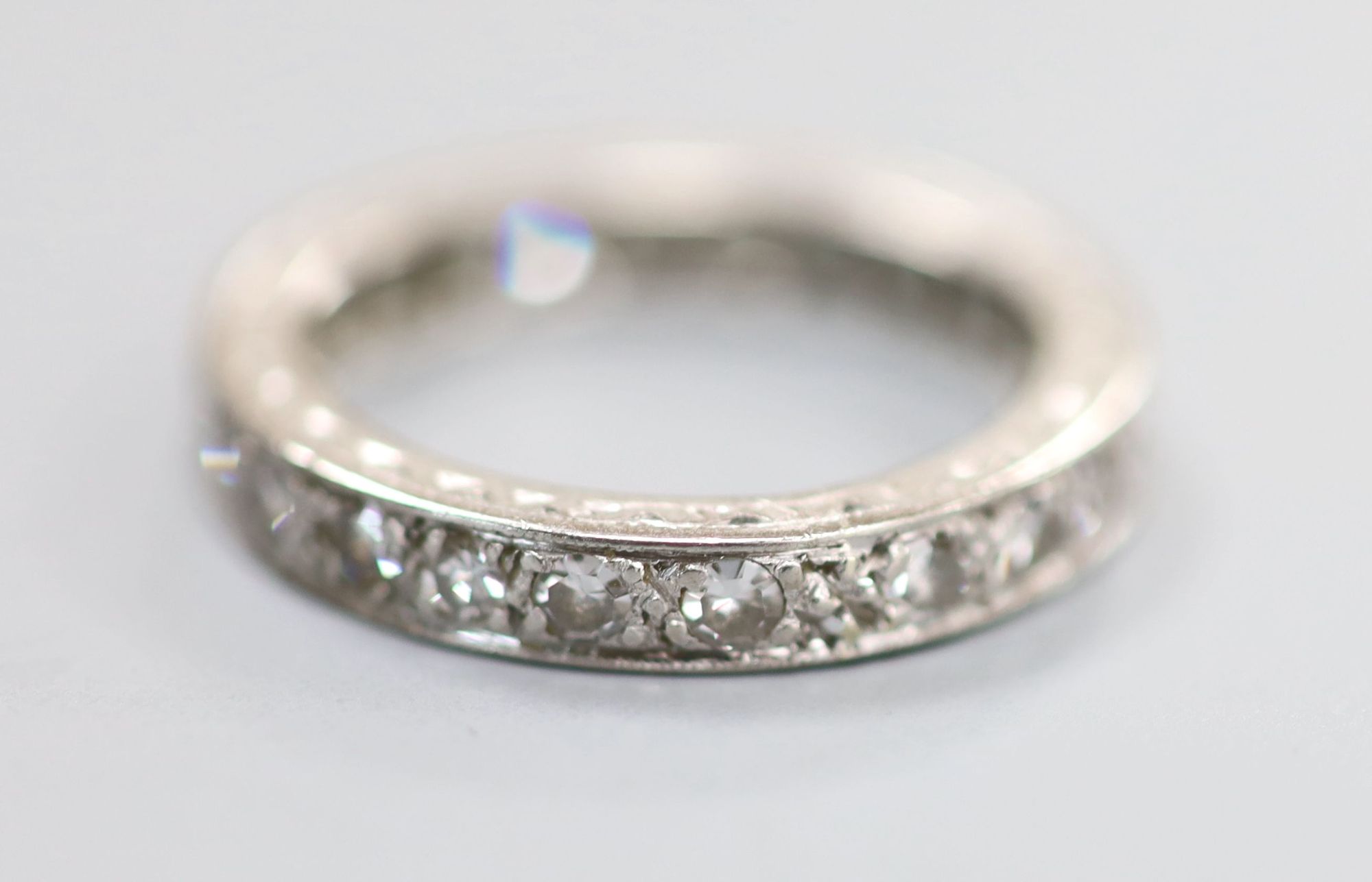 A white metal and diamond set full eternity ring, size K/L, gross 3.5 grams.